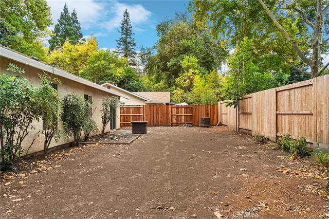 a view of a house with a yard and wooden fence