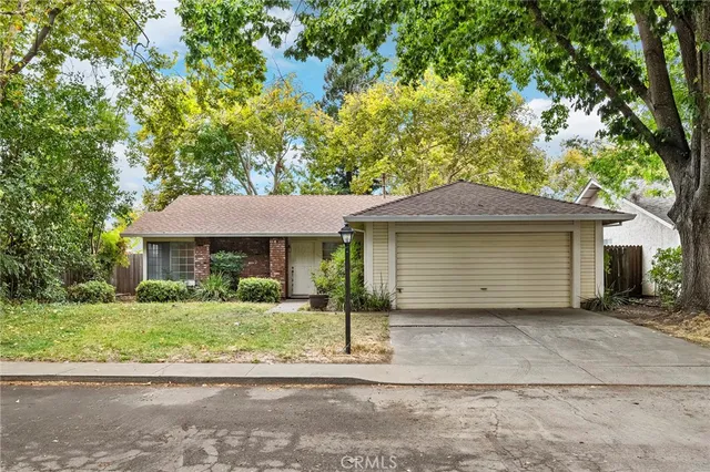 an aerial view of residential houses with outdoor space and trees