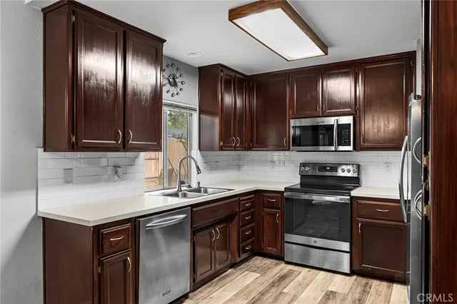 a kitchen with stainless steel appliances granite countertop refrigerator a sink and wooden cabinets