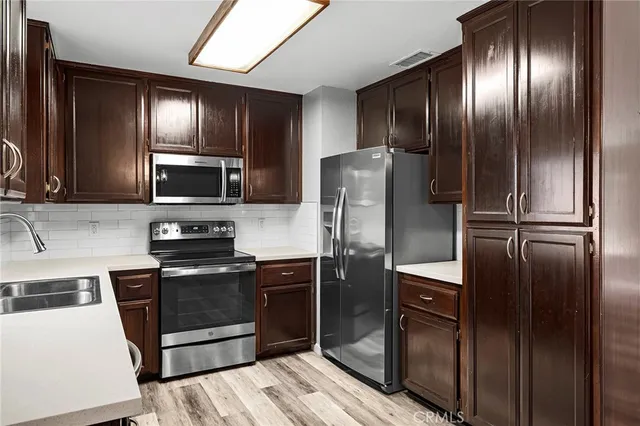a kitchen with stainless steel appliances granite countertop a refrigerator and microwave
