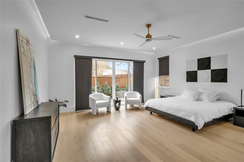 4721 Linnet Lane Dallas, TX 75209 - Photo 11 of 40 a spacious bedroom with a large bed and a chandelier