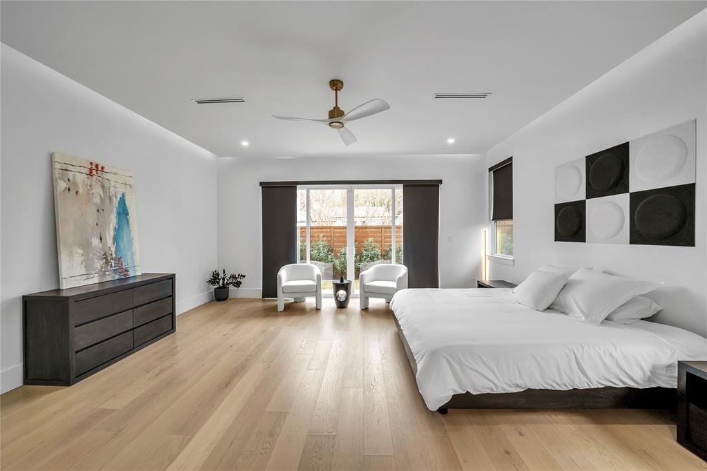 4721 Linnet Lane Dallas, TX 75209 - Photo 12 of 40 a spacious bedroom with a large bed and a chandelier