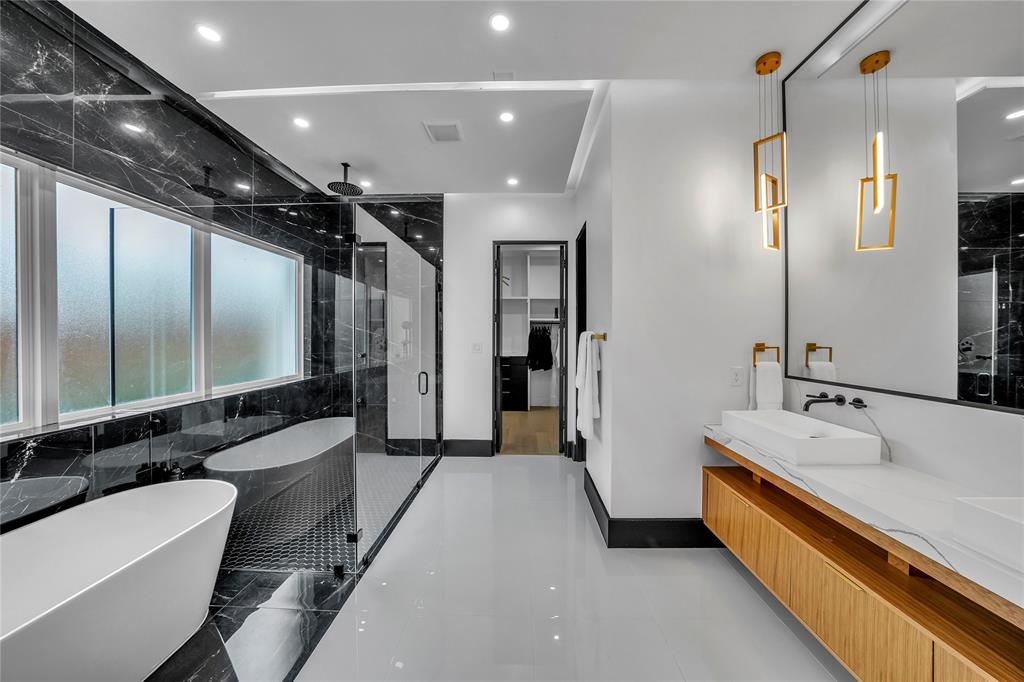 4721 Linnet Lane Dallas, TX 75209 - Photo 17 of 40 a large bathroom with a double vanity sink a large mirror and shower