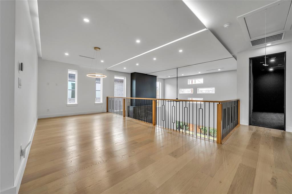 4721 Linnet Lane Dallas, TX 75209 - Photo 29 of 40 a view of an empty room with wooden floor and a kitchen
