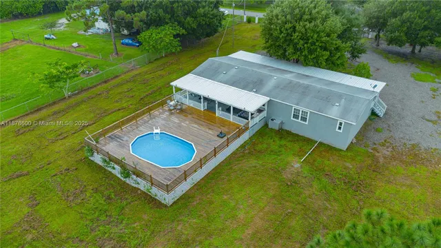 an aerial view of a house with pool yard and outdoor seating