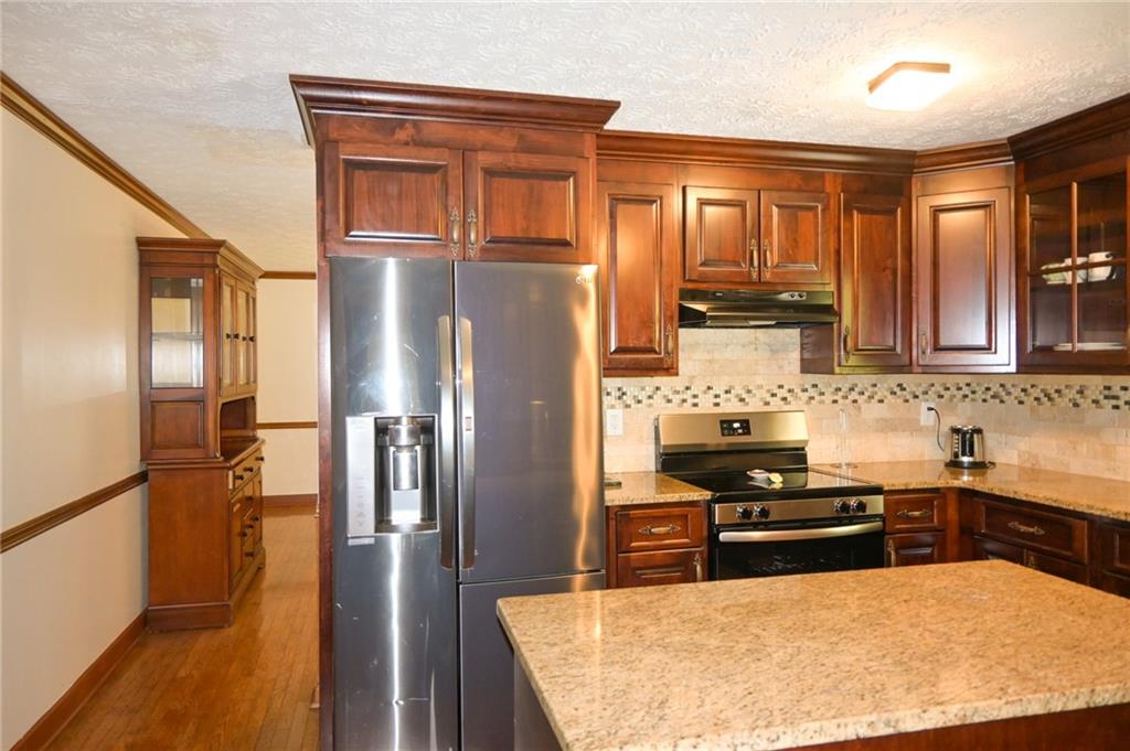 2755 Langley Road Southwest Loganville, GA 30052 - Photo 23 of 49 a kitchen with stainless steel appliances granite countertop a refrigerator a stove and a sink
