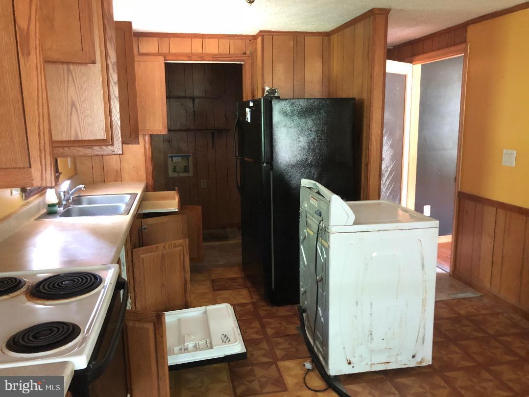 12484 Rousby Hall Road Lusby, MD 20657 - Photo 7 of 11 a kitchen with a refrigerator and a sink