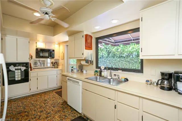 a kitchen with a sink appliances cabinets and a counter top space