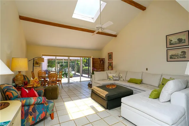 a living room with lots of furniture and a floor to ceiling window