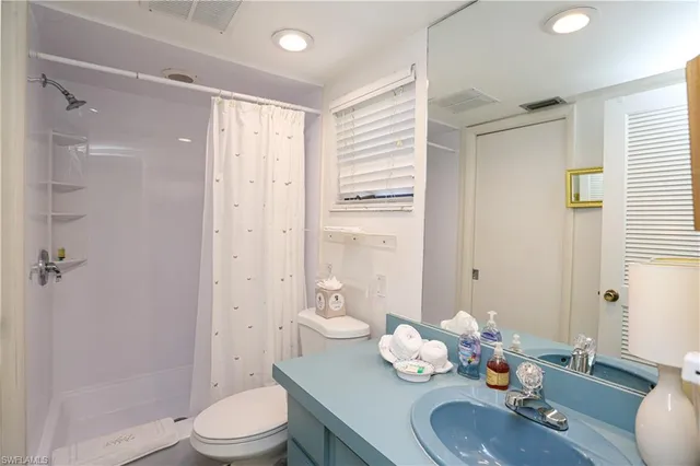 a bathroom with a granite countertop sink toilet a mirror and shower