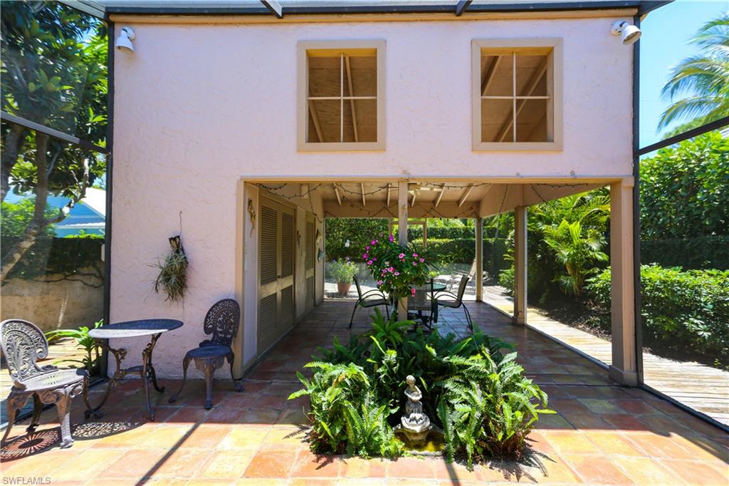 550 3rd Avenue North Naples, FL 34102 - Photo 37 of 48 a patio with table and chairs potted plants