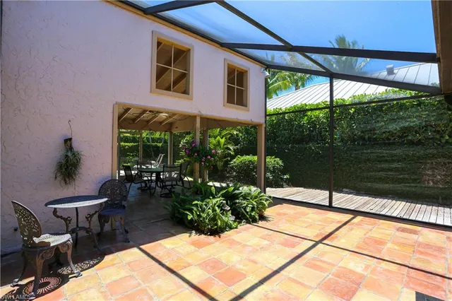 a view of a patio with a table and chairs under an umbrella