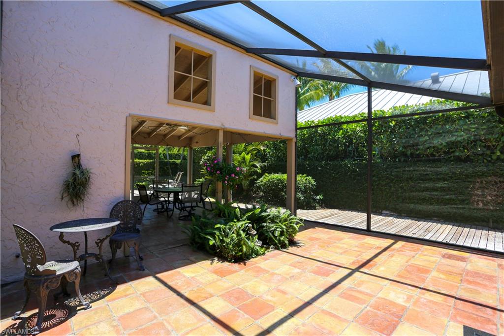 550 3rd Avenue North Naples, FL 34102 - Photo 38 of 48 a view of a patio with a table and chairs under an umbrella