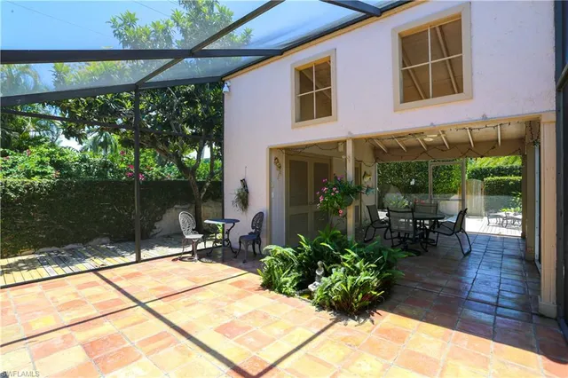a view of a patio with table and chairs potted plants with wooden floor and fence