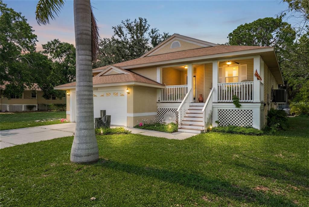 1312 Gulf Road Tarpon Springs, FL 34689 - Photo 1 of 1 a front view of a house with a garden and yard