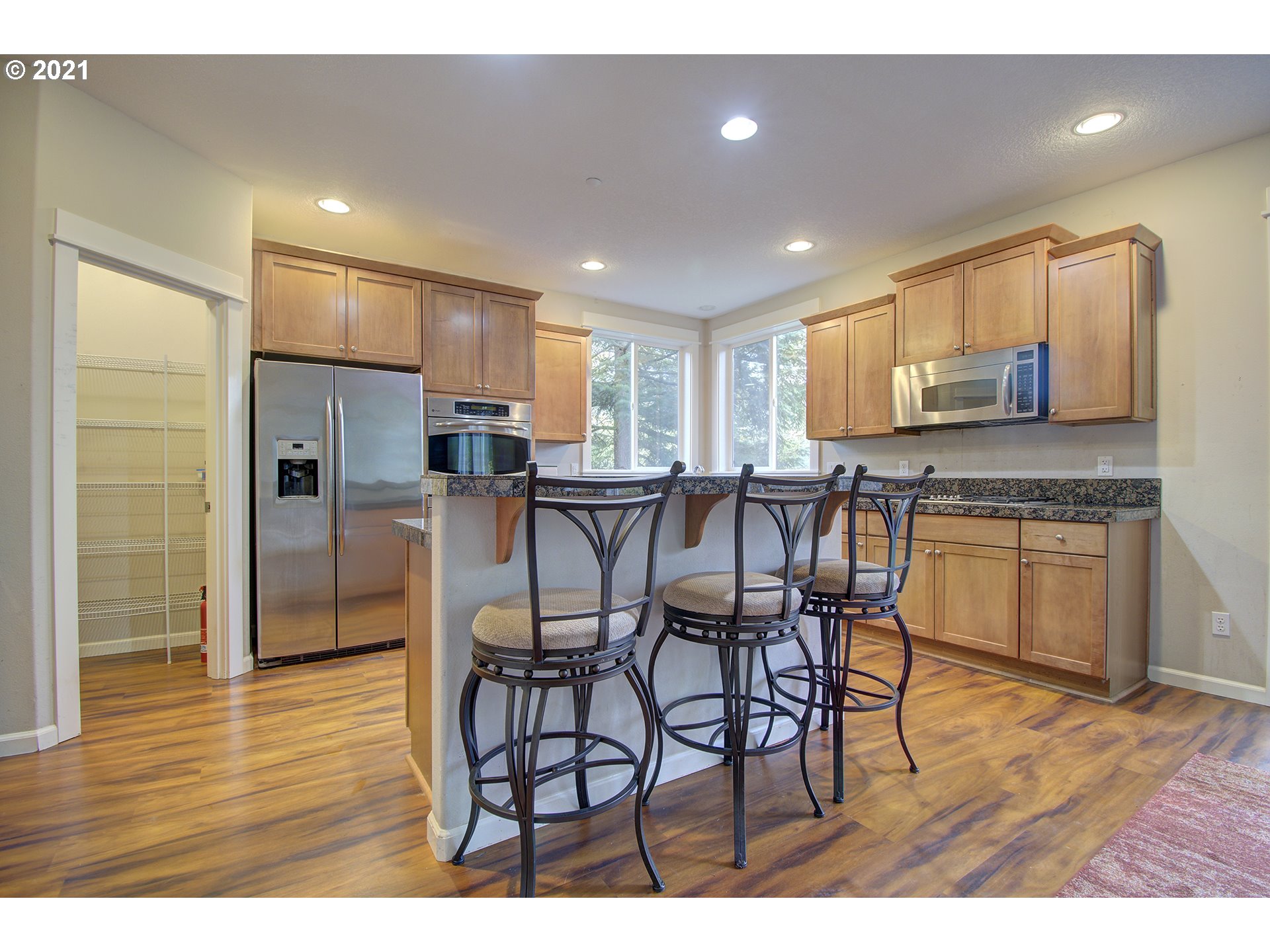 6909 Northeast Lessard Road Camas, WA 98607 - Photo 4 of 30 a kitchen with stainless steel appliances kitchen island granite countertop a refrigerator a stove a sink dishwasher with a dining table and chairs