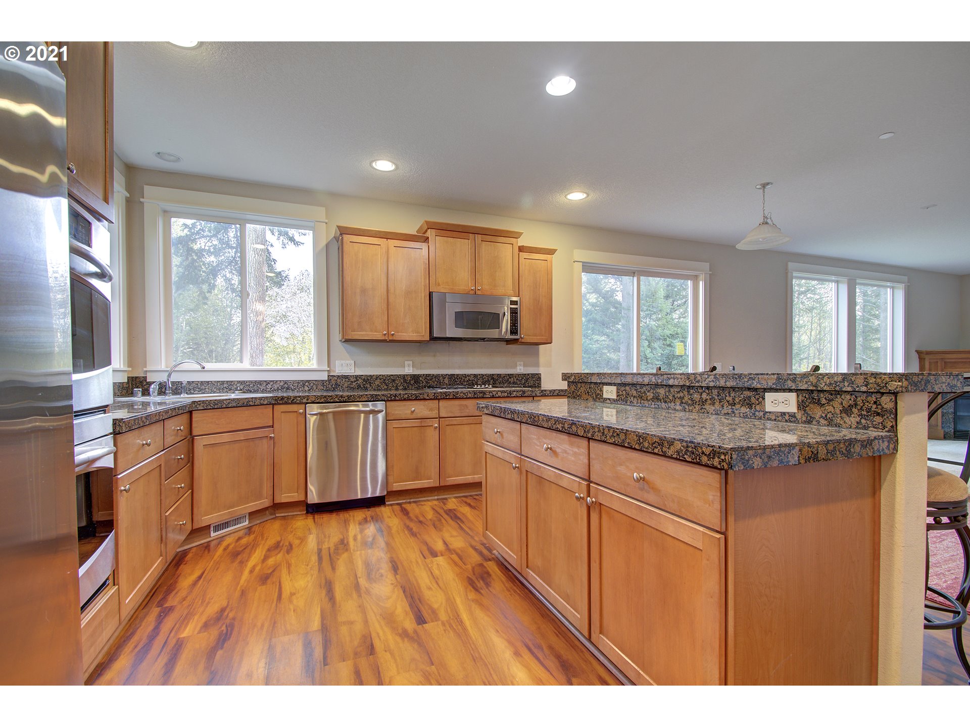 6909 Northeast Lessard Road Camas, WA 98607 - Photo 5 of 30 a large kitchen with granite countertop a large counter top space a sink stainless steel appliances and windows
