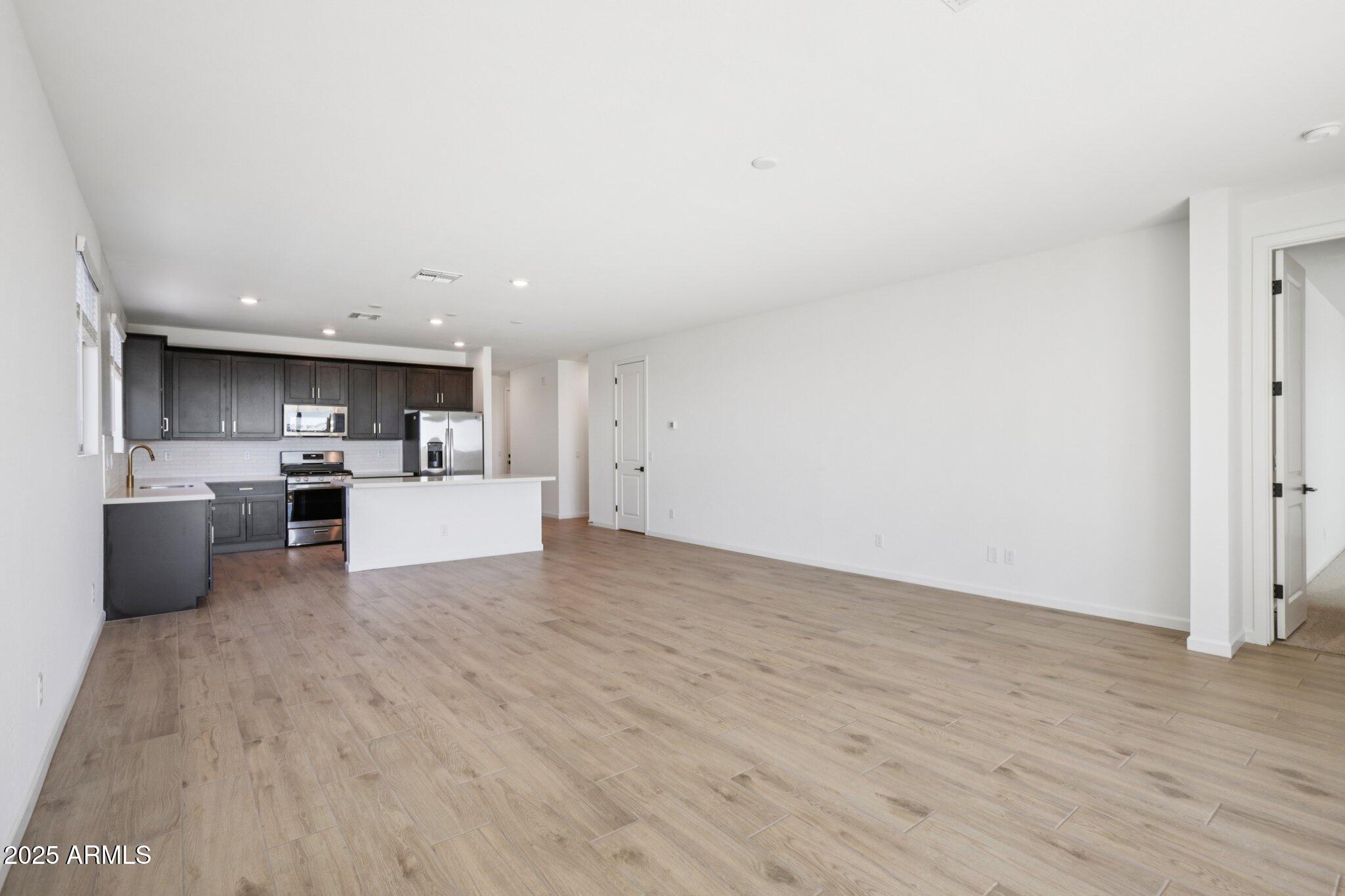 16219 West Bajada Road Surprise, AZ 85387 - Photo 7 of 43 a view of a kitchen with furniture and wooden floor