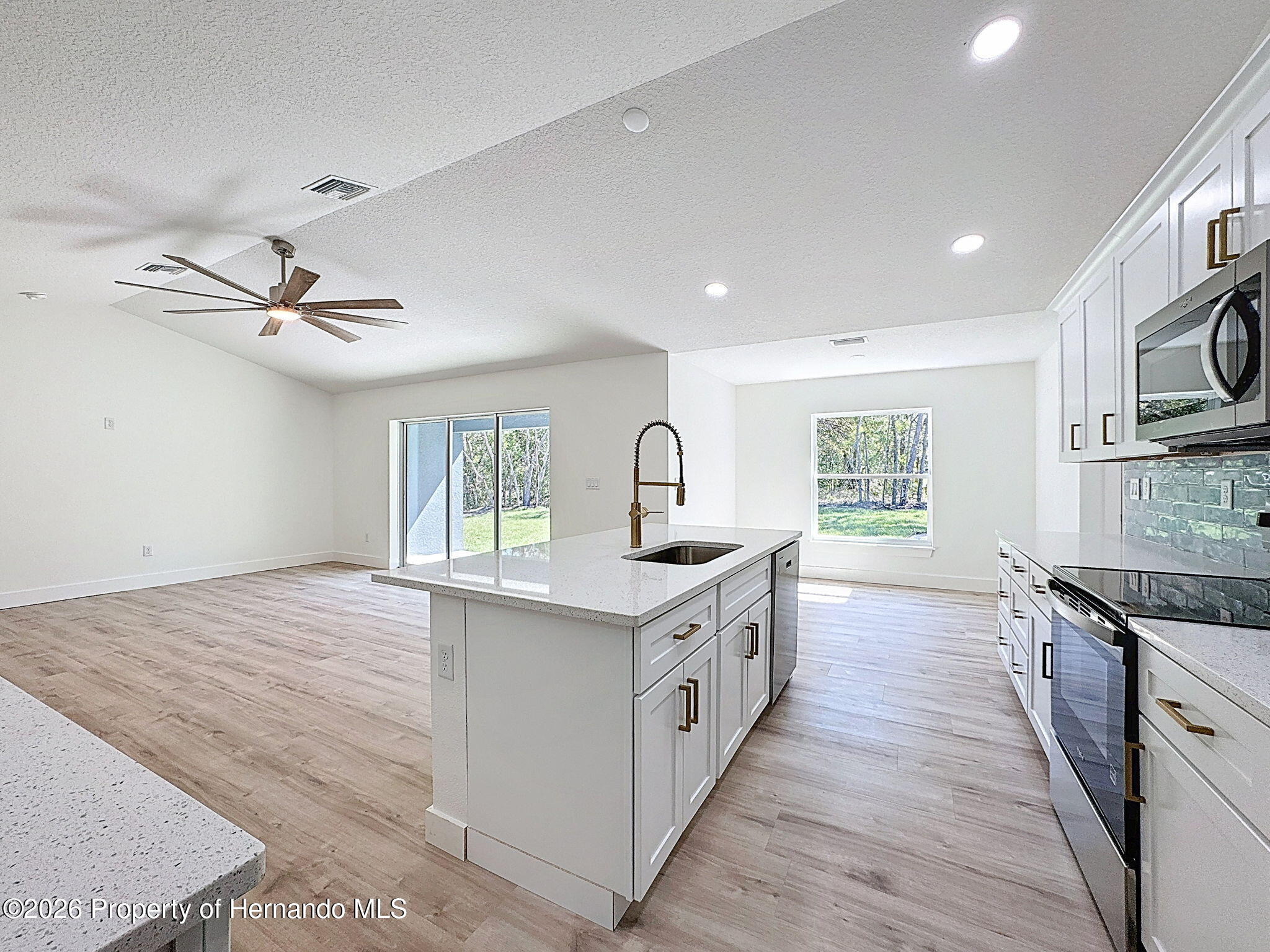 8988 Waterbird Way Weeki Wachee, FL 34613 - Photo 18 of 42 a kitchen with stainless steel appliances granite countertop a sink stove and refrigerator