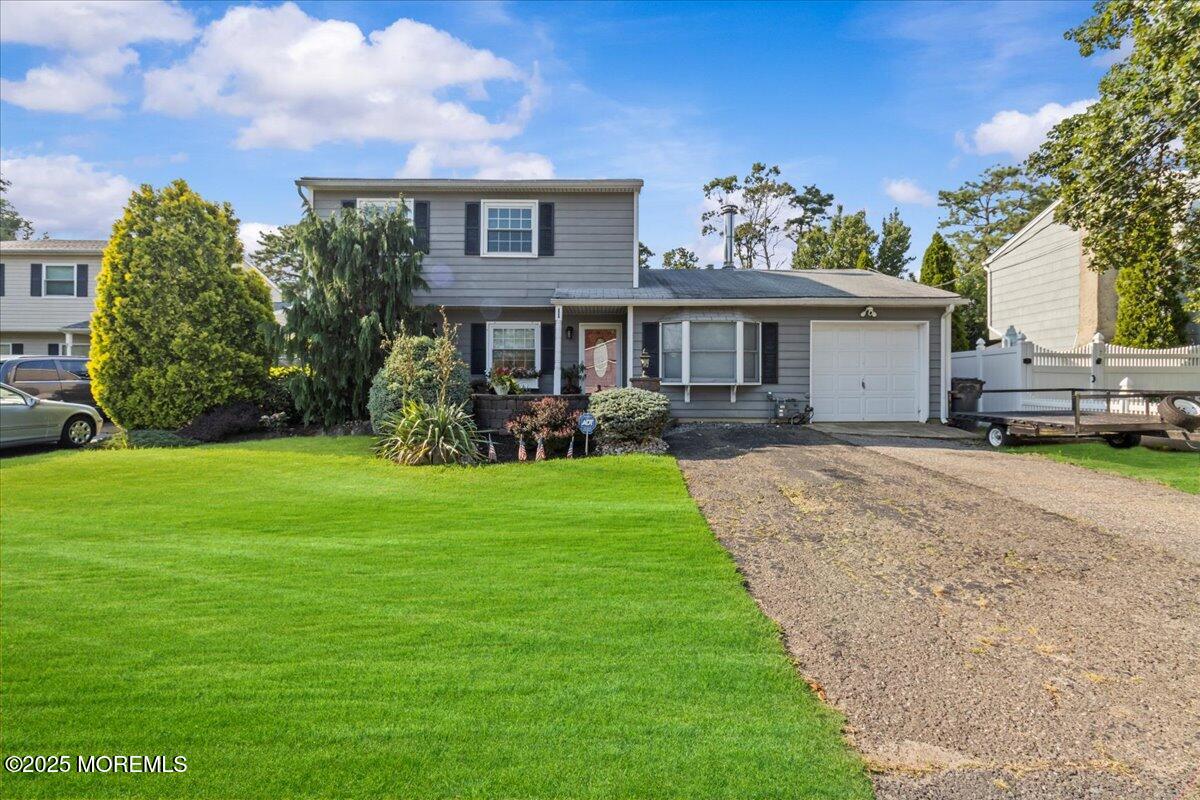 2110 Lanes Mill Road Brick, NJ 08724 - Photo 2 of 55 a front view of a house with a garden and trees