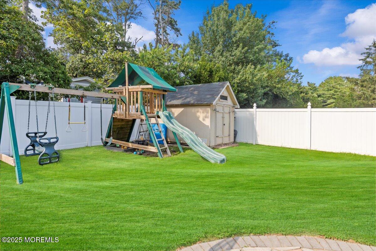2110 Lanes Mill Road Brick, NJ 08724 - Photo 36 of 55 a view of a backyard with a slide trees and wooden fence