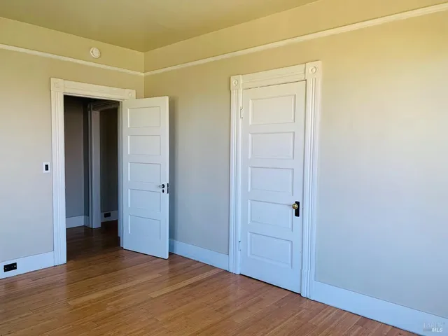 an empty room with wooden floor and closet