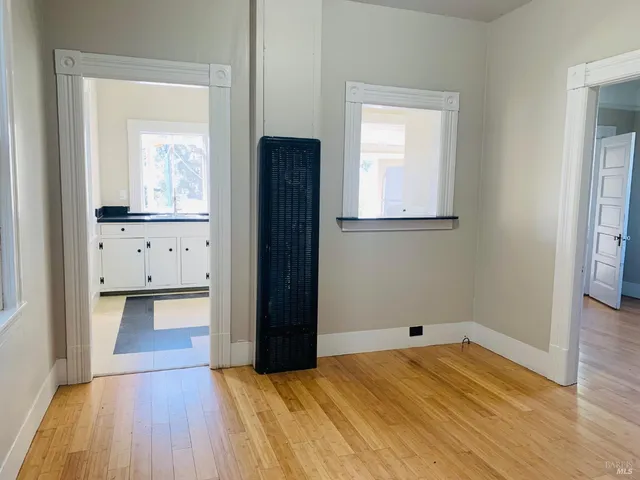 a view of empty room with wooden floor and cabinet