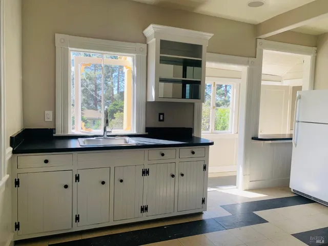 a kitchen with granite countertop white cabinets and a window