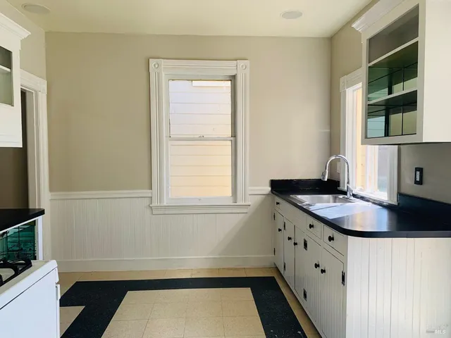 a bathroom with a granite countertop sink and a window
