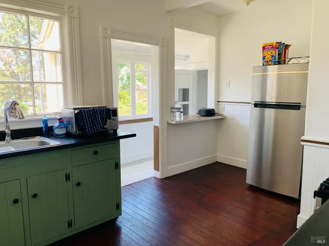 a kitchen with stainless steel appliances granite countertop a refrigerator sink and dishwasher with wooden floor