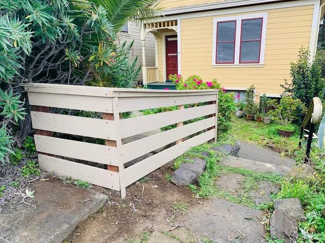 a view of a house with a yard and wooden fence
