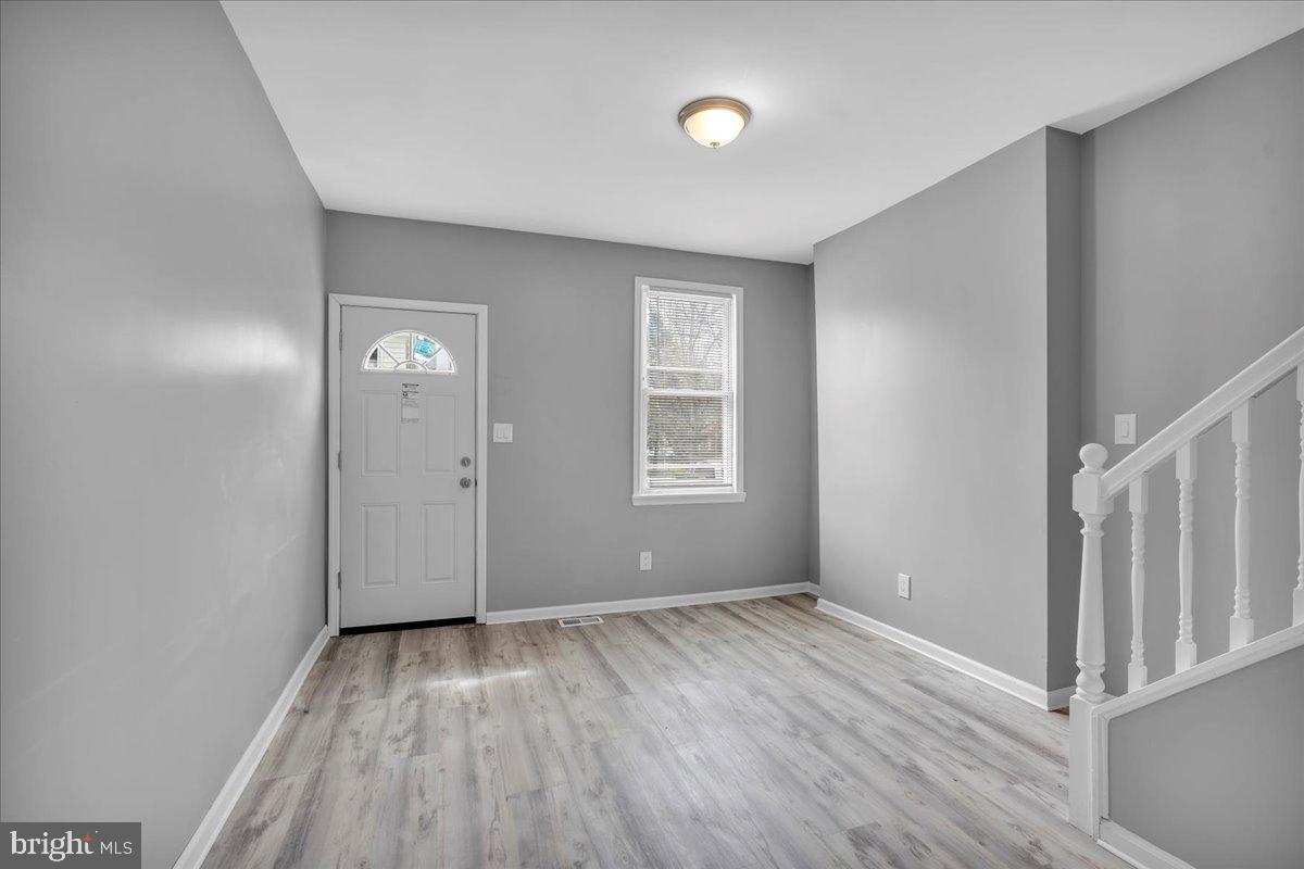 407 Powell Street Gloucester City, NJ 08030 - Photo 3 of 22 an empty room with wooden floor and windows