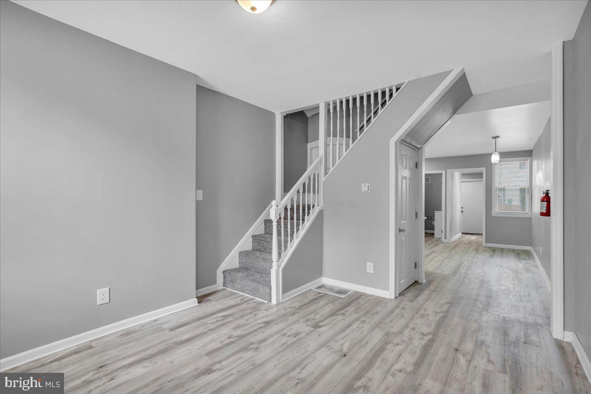407 Powell Street Gloucester City, NJ 08030 - Photo 4 of 22 a view of a hallway with wooden floor and staircase