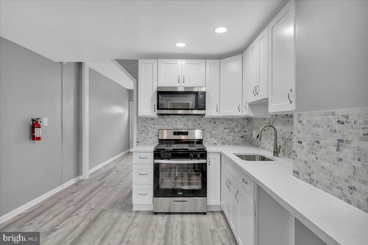 407 Powell Street Gloucester City, NJ 08030 - Photo 5 of 22 a kitchen with a sink stove and microwave