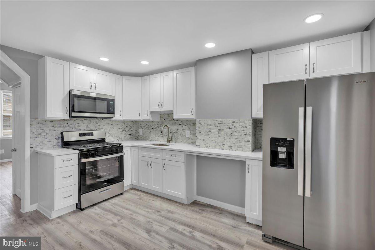 407 Powell Street Gloucester City, NJ 08030 - Photo 6 of 22 a kitchen with stainless steel appliances granite countertop a stove a refrigerator and a microwave