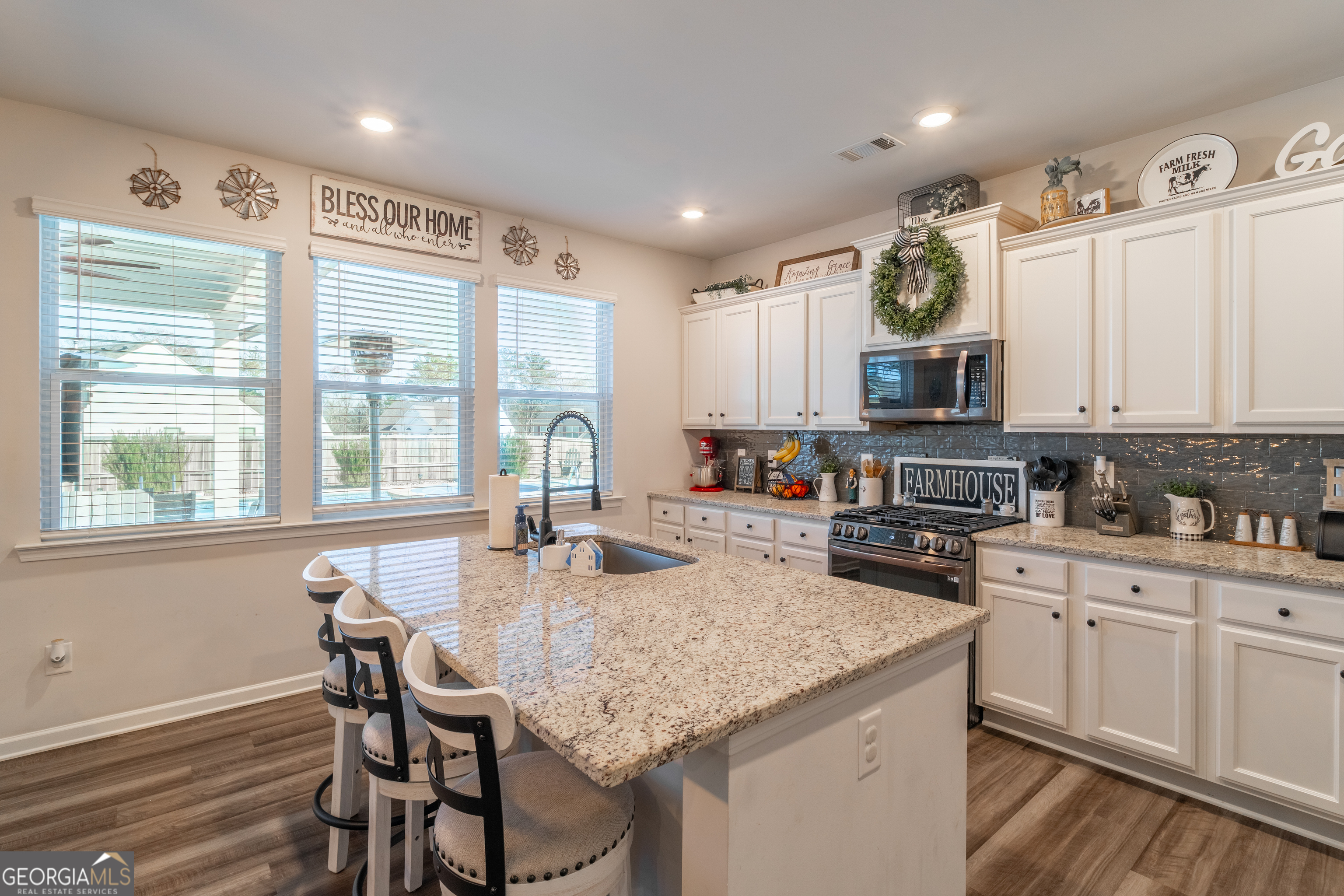 728 Cherokee Rose Bremen, GA 30110 - Photo 22 of 78 a kitchen with kitchen island granite countertop a stove a sink a microwave and wooden cabinets