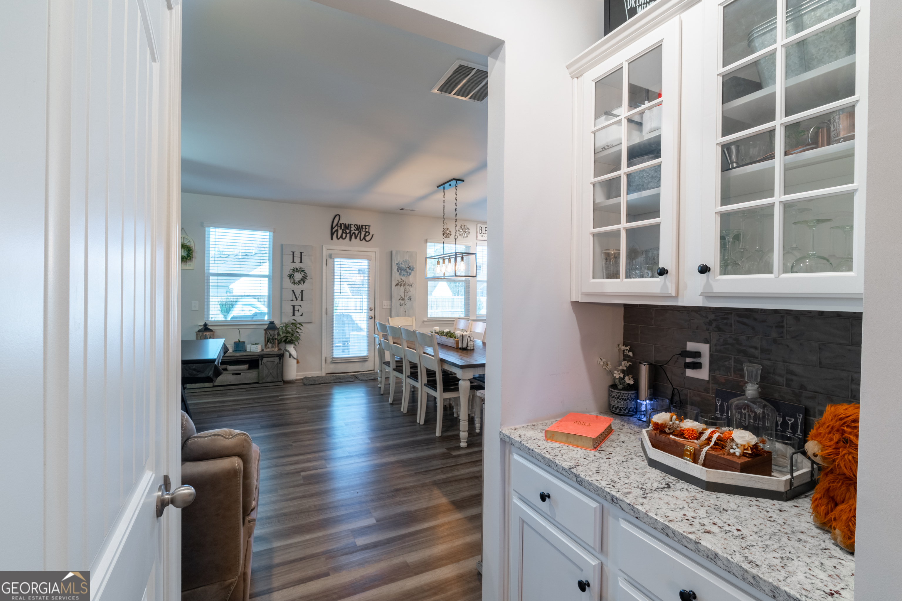 728 Cherokee Rose Bremen, GA 30110 - Photo 7 of 78 an open kitchen with granite countertop a stove a sink a dining table and chairs with wooden floor