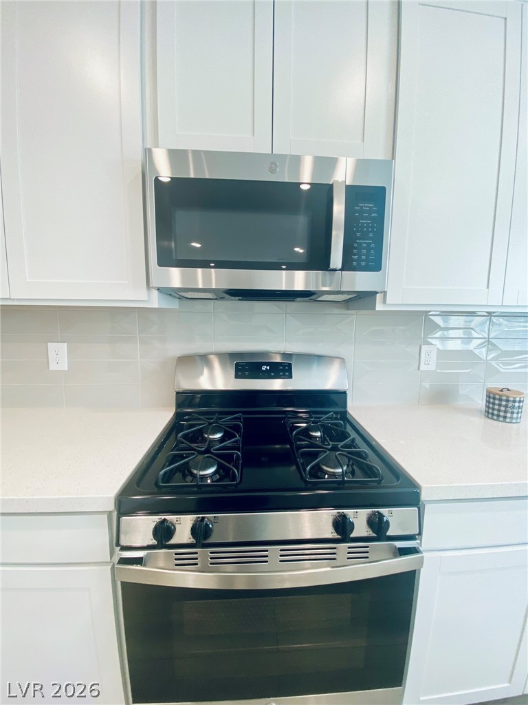 4457 Sawyer Ridge Street Las Vegas, NV 89147 - Photo 14 of 32 This modern kitchen features sleek appliances, perfect for culinary enthusiasts.