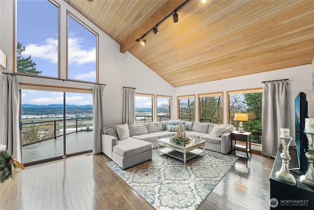 a living room with furniture tv and a floor to ceiling window