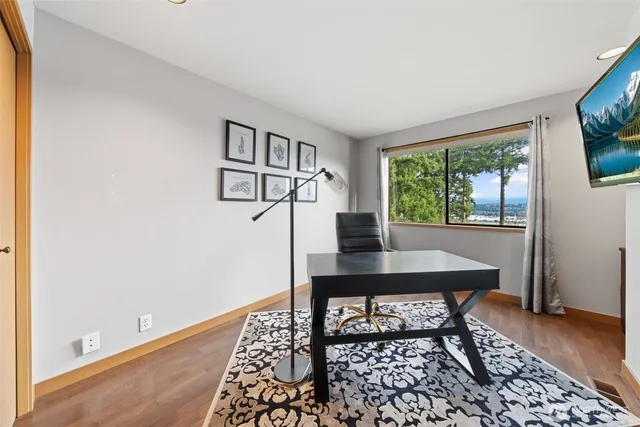 a view of a workspace with furniture and a window