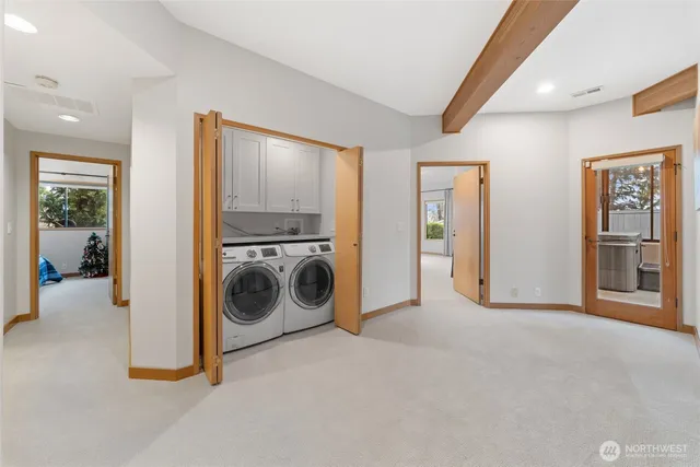 a view of a hallway with washer and dryer to ceiling window