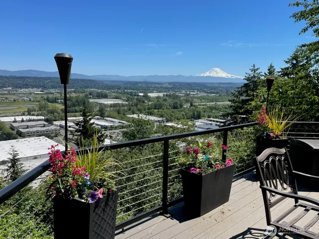 a view of a balcony and chairs next to a yard