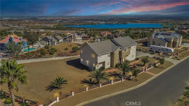 an open kitchen with granite countertop a stove and white cabinets with wooden floor