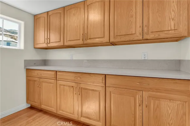 a kitchen with granite countertop white cabinets and a wooden floors