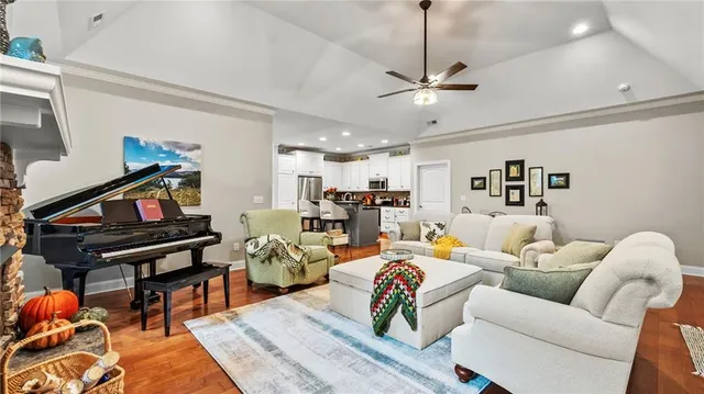 a living room with furniture a wooden floor and a piano