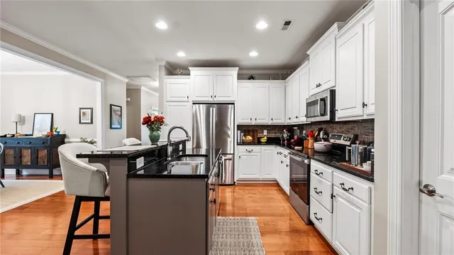 a kitchen with stainless steel appliances granite countertop a refrigerator and a stove top oven