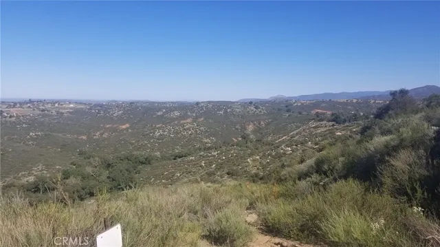 a view of a dry yard with mountains in the background