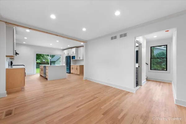 a view of a big room with wooden floor and a kitchen