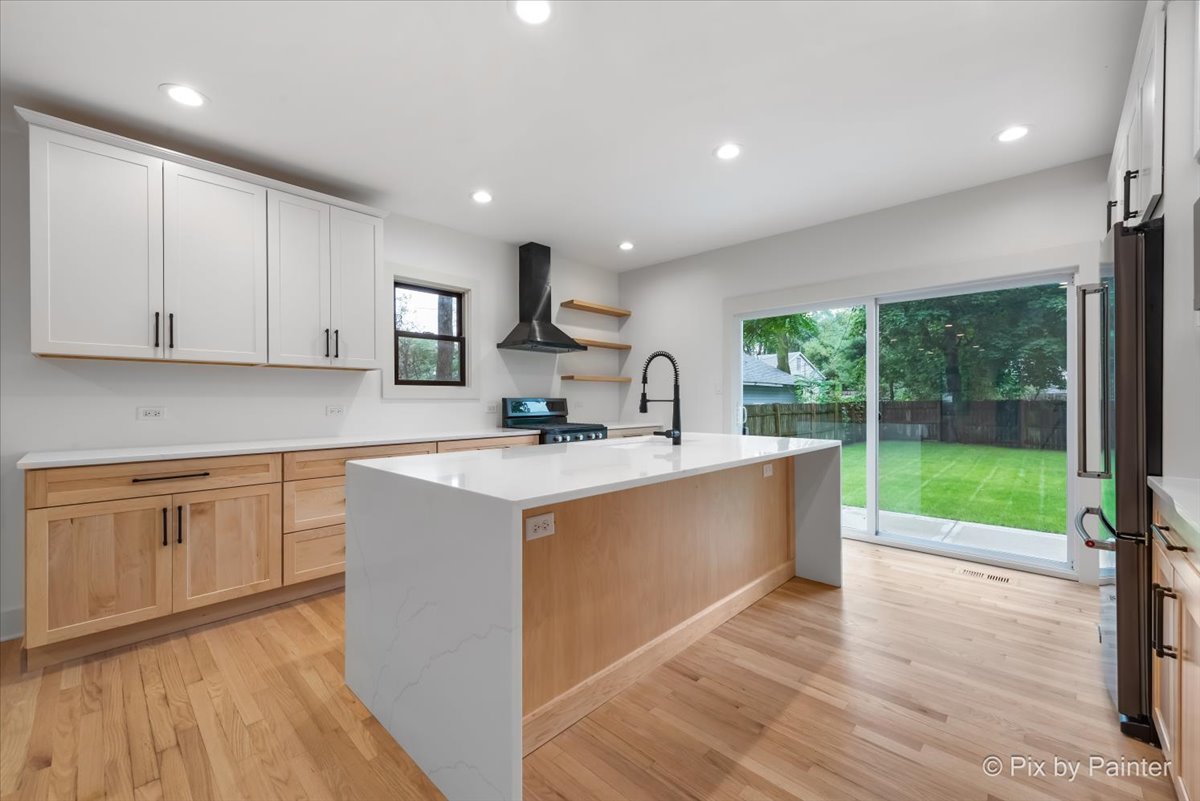 518 Illinois Street Geneva, IL 60134 - Photo 6 of 41 a large kitchen with kitchen island a large counter top space a sink stainless steel appliances and cabinets