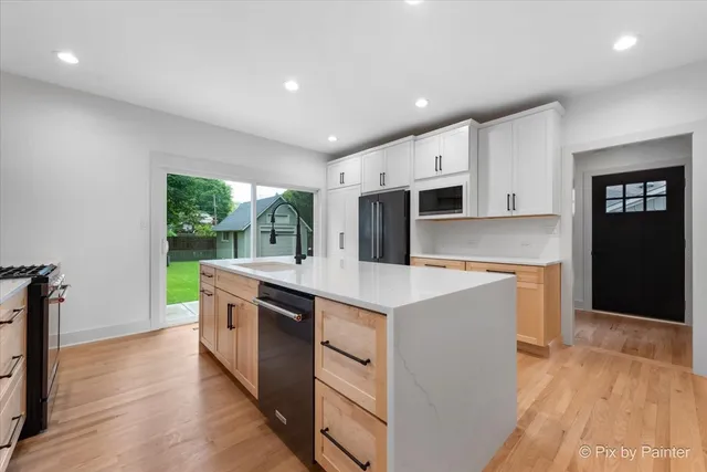 a kitchen with kitchen island a sink stove and wooden floor